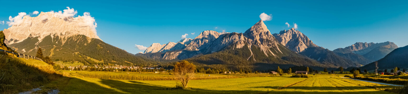 High resolution stitched panorama of a beautiful alpine summer view with the famous Zugspitze and Sonnenspitze summits in the background near Lermoos, Tyrol, Austria