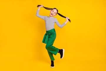 Full length photo of young excited girl happy positive smile have fun fooling isolated over yellow color background