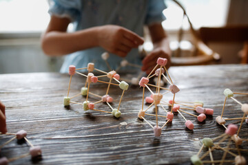 Children play with marshmallows and toothpicks, edible designer in the kitchen. Educational classes...