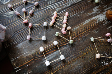 Children play with marshmallows and toothpicks, edible designer in the kitchen. Educational classes...