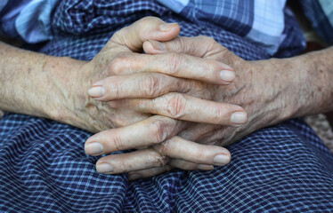 Clasped hands of Asian man. Concept of rheumatoid arthritis, osteoarthritis or joint pain.