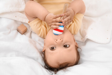 Obraz na płótnie Canvas Cute little baby with toy lying in comfy crib