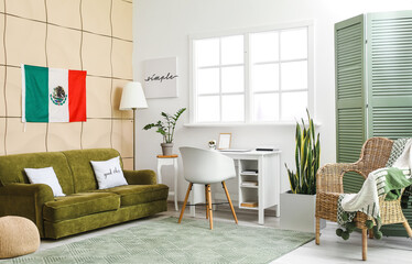 Interior of stylish living room with sofa, workplace and hanging Mexican flag
