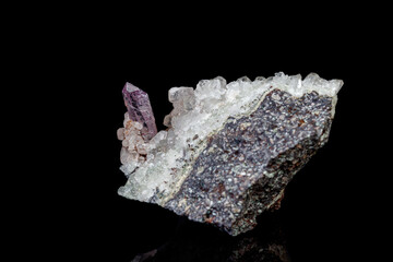 macro mineral amethyst stone in rock on a black background