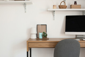 Modern workplace with humidifier near light wall