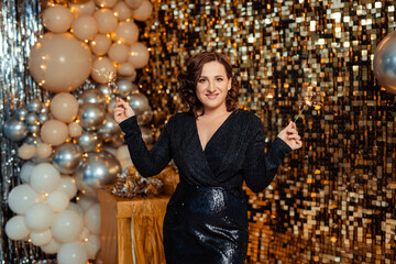 beautiful young woman in a stunning black dress with sparklers Party New Years