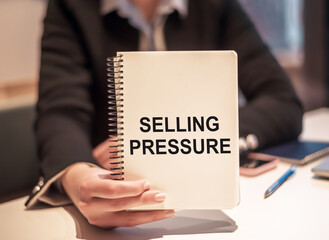 Selling Pressure on a notepad in businesswoman hand. Business plan concept.