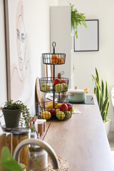 Stand with healthy fruits on counter in modern kitchen