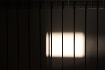 Sunlight from the window on the white surface of the sections of the radiator