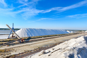 Obraz premium Les salins d'Aigues-Mortes dans le Grad (France). Confection de grands tas de sel grâce à la trémie.
