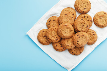 Oatmeal cookies on a blue background and a white napkin top view