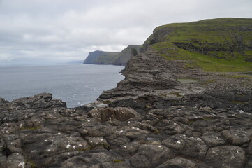 Fototapeta na wymiar The green and blue dramatic and wild coastal landscapes in the Faroe Islands