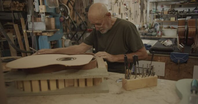 Luthier filing a guitar mold