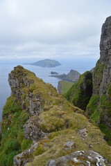 The green and blue dramatic and wild coastal landscapes in the Faroe Islands