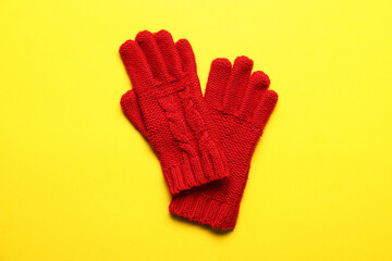 Knitted warm gloves on yellow background