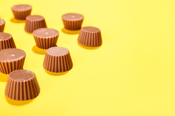 Tasty peanut butter cups on color background