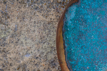 Oxidized copper plate with remnants of Himalayan salt. Blue-green patina. Stone background. Copy...