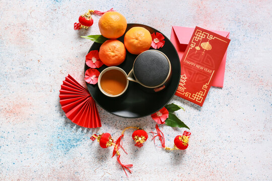 Red envelopes with tea and Chinese symbols on light background. New Year celebration
