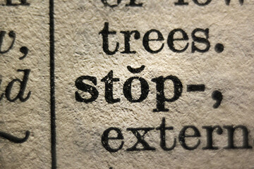 Word "stop" and "violent" printed on book page, macro close-up