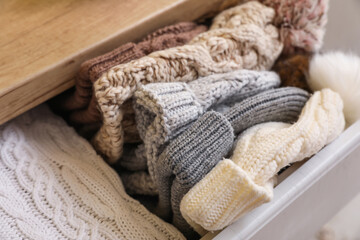Fototapeta na wymiar Knitted hats in chest of drawers