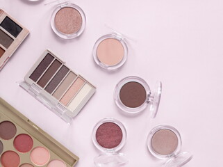 Make up layout,eye shadow on pastel pink background. Minimal and luxury make up, cosmetic or beauty salon composition. Flat lay, top view, copy space.