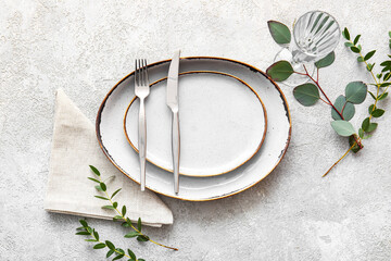 Beautiful table setting for wedding with eucalyptus on light background