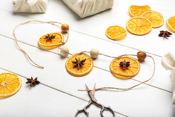 Handmade Christmas toys and scissors on white wooden background