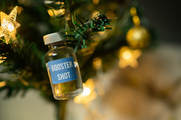 Covid-19 booster shot vaccine on a Christmas tree