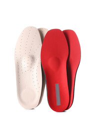 Beige and red orthopedic insoles on white background