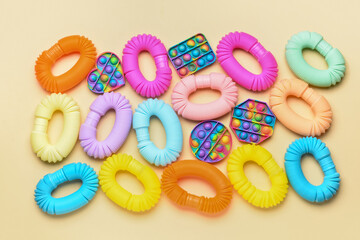 Colorful Pop Tubes and Pop it fidget toys on yellow background