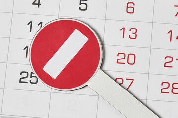 Close-up view of monthly calendar and No entry traffic sign. Symbol of cancellation, forbidding and...