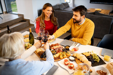 Happy family having dinner with red wine at home