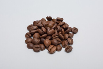 Roasted coffee beans on a white background.
