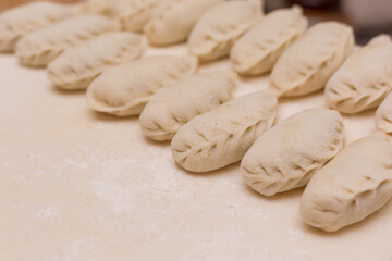 Fototapeta na wymiar Uncooked dumplings at cutting board. Homemade preparation food.