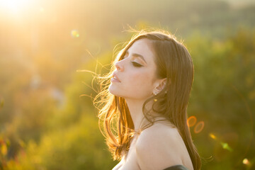 Close up face of young stylish woman. Beautiful fashionable girl outdoor portrait. Young woman outdoor enjoying the sunlight. Young woman on sunny spring day, soft sunny colors.