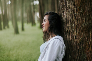 Fototapeta premium Mujer joven con pelo largo sonriendo en bosque