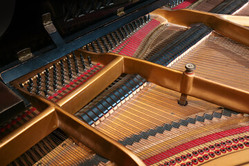 Inside a grand piano, metal frame, strings and mechanics of the old acoustic musical instrument, music themes, selected focus