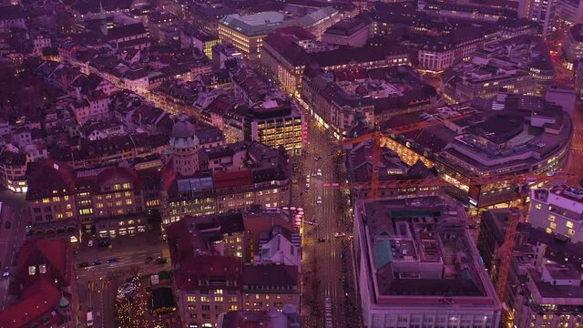 Aerial drone footage of the sunset over Zurich city center and financial district in Switzerland largest city, with a forward motion along the Bahnhof street