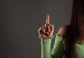 Young woman pointing finger to the up
