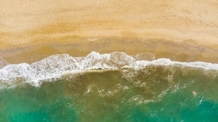 Aerial view of sandy beach and ocean with waves