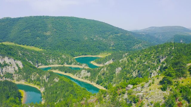 Winding blue river Meandri Cehotine on the mountains with green forest in Pljevlja, Montenegro. Aerial drone view.