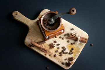 Coffee grinder, heart shaped coffee beans and cinnamon on a wooden surface. a cup of aromatic...