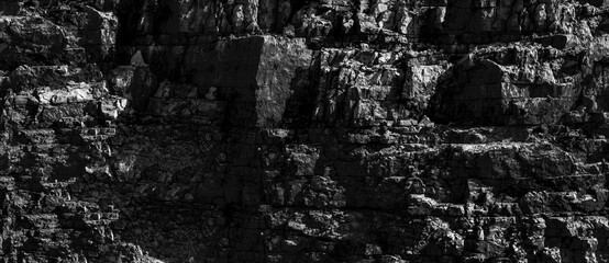 Grungy cragged bumpy pitted cavity stone facade, split layer gap.Ruined cracked shattered worn rough hiking canyon.Old ragged grunge steep marble cliff. Grand vintage crannied damaged impressive gorge