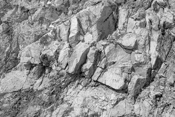 Grungy cragged bumpy pitted cavity stone facade, split layer gap.Ruined cracked shattered worn rough hiking canyon.Old ragged grunge steep marble cliff. Grand vintage crannied damaged impressive gorge