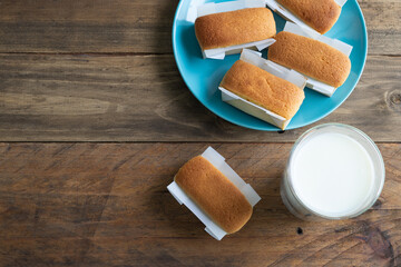 Mantecadas typical Spanish dessert. Cupcakes and a glass of milk on a wooden base. Copy space.