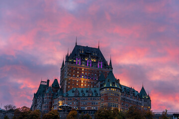 Naklejka premium Quebec City Old Town Fairmont Le Chateau Frontenac in autumn dusk, stunning pink and yellow clouds over the sky in the evening.