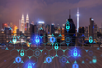 Rooftop with wooden terrace, Kuala Lumpur night skyline. Cyber security concept to protect clients confidential information. IT hologram padlock icons. City downtown. Double exposure.