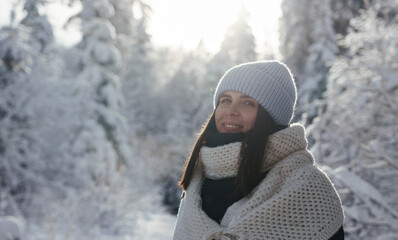 Portrait of smiling woman outdoor in snowy sunny forest with copy space