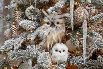 Christmas toy in the form of an owl and her little cub on a decorated Christmas tree