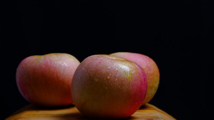 Fototapeta na wymiar Apples with water droplets look fresh and delicious. food and drink concept. Black Background.